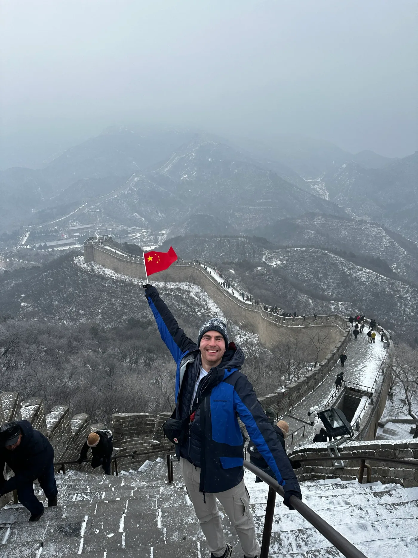 Dejan waving a flag on the Great Wall of China in fog